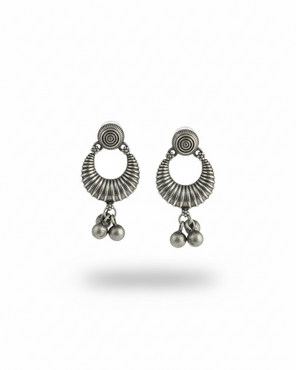 Pair of silver earrings with circular designs and dangling beads on a white background